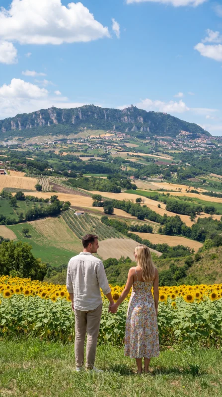 Coppia tra i girasoli con vista su San Marino