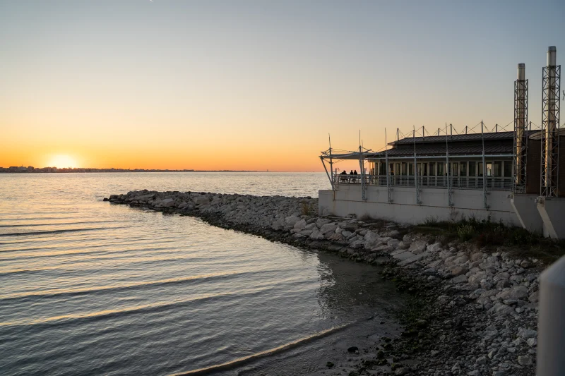 Tramonto sulla Riviera Romagnola con edificio panoramico sul mare