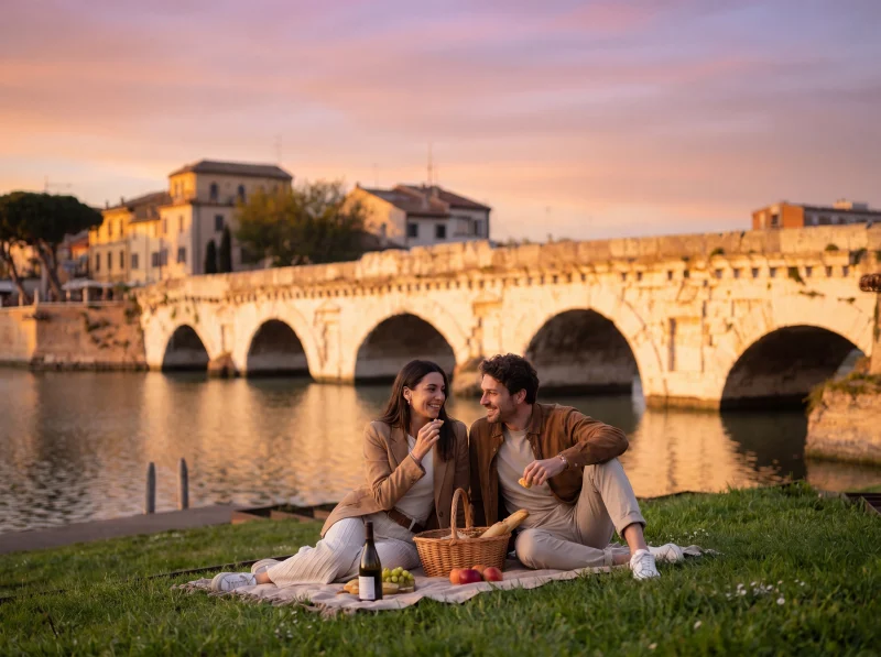 Picnic romantico al tramonto con vista sul Ponte Tiberio a Rimini