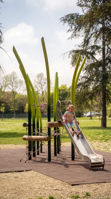 Bambina che gioca su uno scivolo in un parco pubblico di Rimini