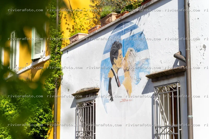 Murales di bacio iconico in un angolo urbano della Riviera Romagnola