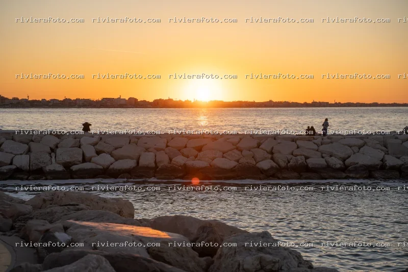 Tramonto sulla Riviera Romagnola con scogliera e skyline urbano