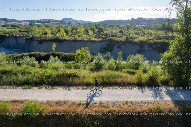 Ciclista su strada bianca nel paesaggio collinare romagnolo