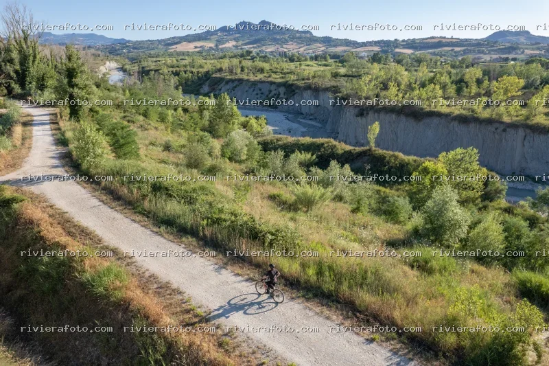 Ciclista nel paesaggio collinare romagnolo con San Marino sullo sfondo