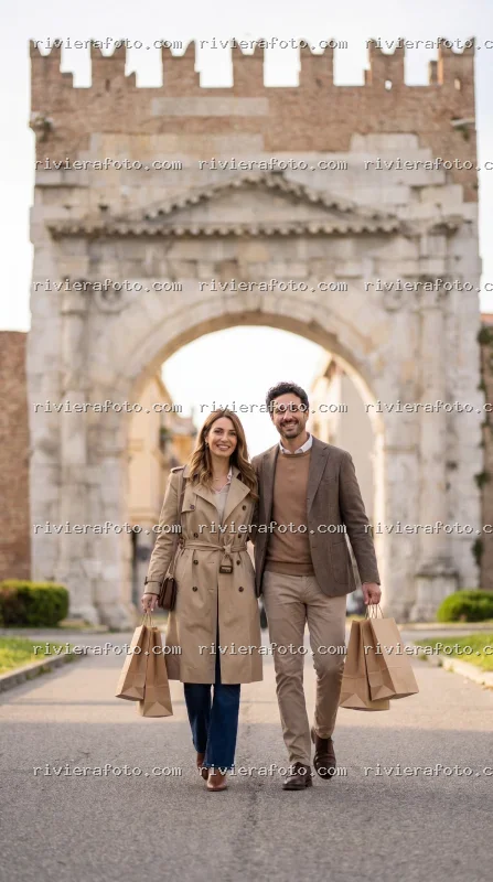 Coppia con shopping davanti all’Arco d’Augusto a Rimini