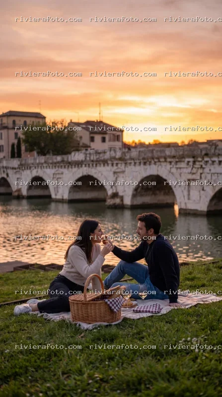 Picnic al tramonto sul lungofiume di Rimini con vista sul Ponte Tiberio