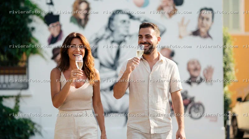 Coppia con champagne davanti a murale artistico nel Borgo San Giuliano di Rimini