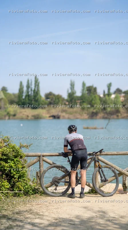 Ciclista in sosta contemplativa nel paesaggio naturale romagnolo di Rimini