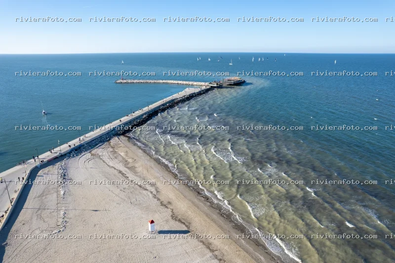 Molo e spiaggia sulla Riviera Romagnola con barche a vela