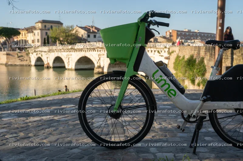 Ponte Tiberio a Rimini con bicicletta Lime in primo piano