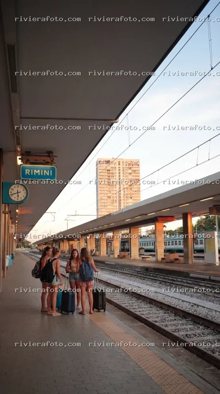Stazione di Rimini al tramonto con viaggiatori