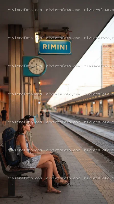 Viaggiatori alla Stazione di Rimini al tramonto