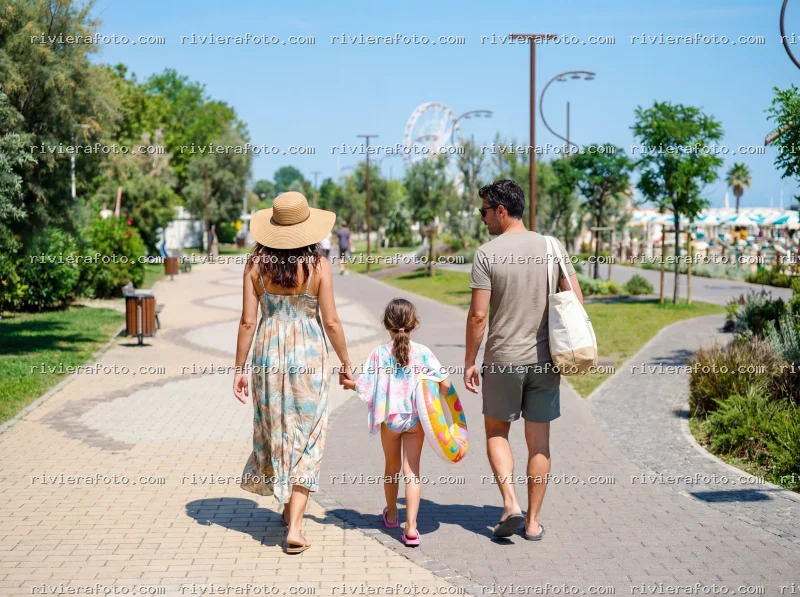 Famiglia in passeggiata sulla promenade di Rimini con vista sulla Ruota Panoramica