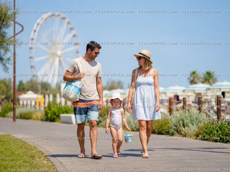 Famiglia in passeggiata sulla Riviera Romagnola con vista sulla Ruota Panoramica