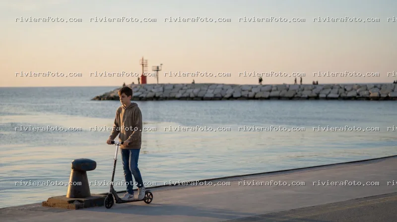 Passeggiata in monopattino sul molo di Rimini sulla Riviera Romagnola al tramonto