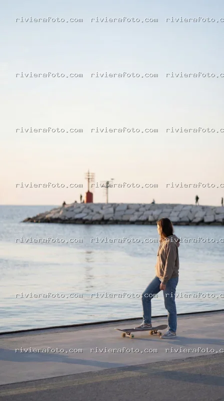 Skateboard sul molo di Rimini, sulla Riviera Romagnola al tramonto