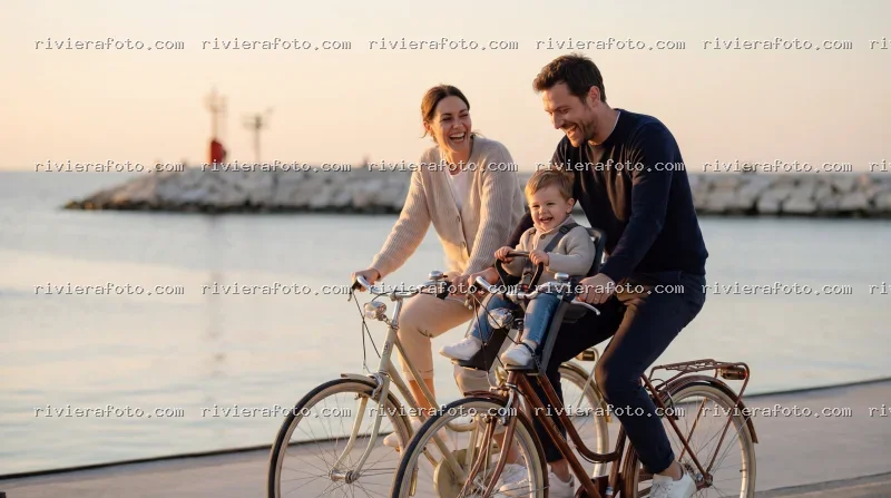 Famiglia in bicicletta a Rimini, sulla Riviera Romagnola al tramonto
