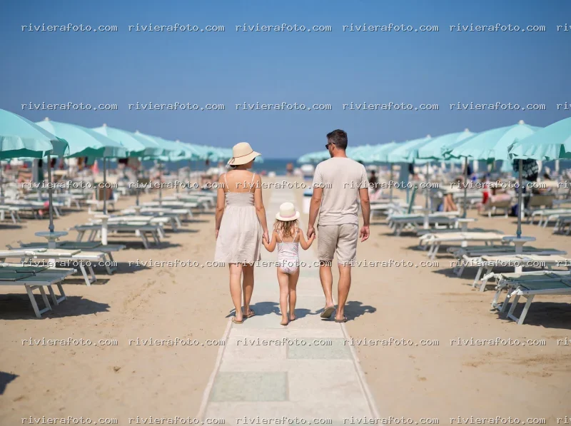 Famiglia in passeggiata sulla spiaggia di Rimini nella Riviera Romagnola