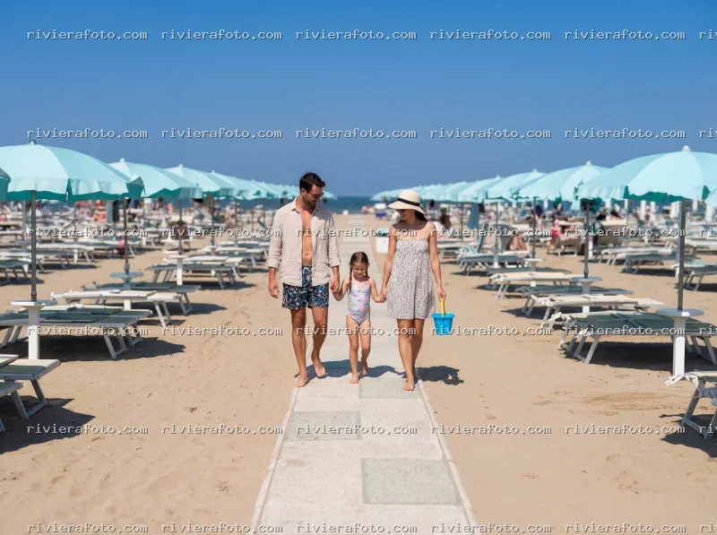 Famiglia in passeggiata sulla spiaggia di Rimini nella Riviera Romagnola