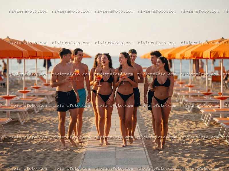 Giovani in costume con cocktail sulla spiaggia di Rimini nella Riviera Romagnola