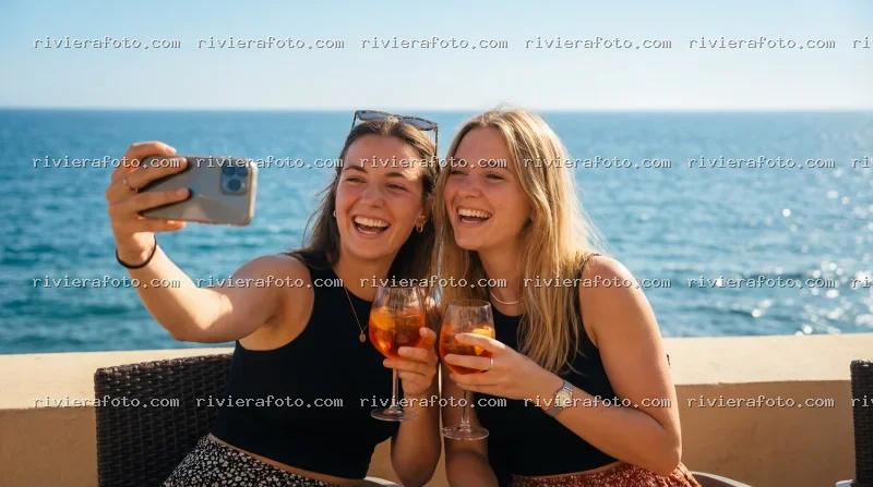 Amiche brindano con Aperol Spritz con vista mare sulla Riviera Romagnola a Rimini