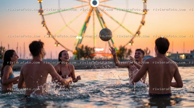 Giovani che giocano in mare al tramonto con ruota panoramica a Rimini