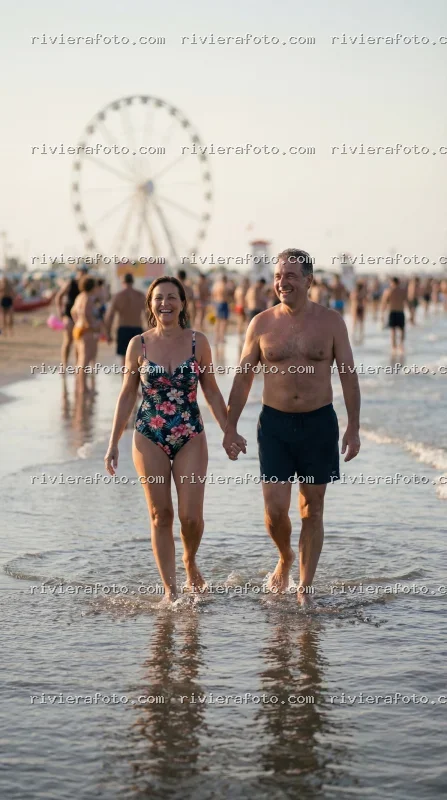 Passeggiata serale di coppia sulla spiaggia di Rimini sulla Riviera Romagnola con ruota panoramica