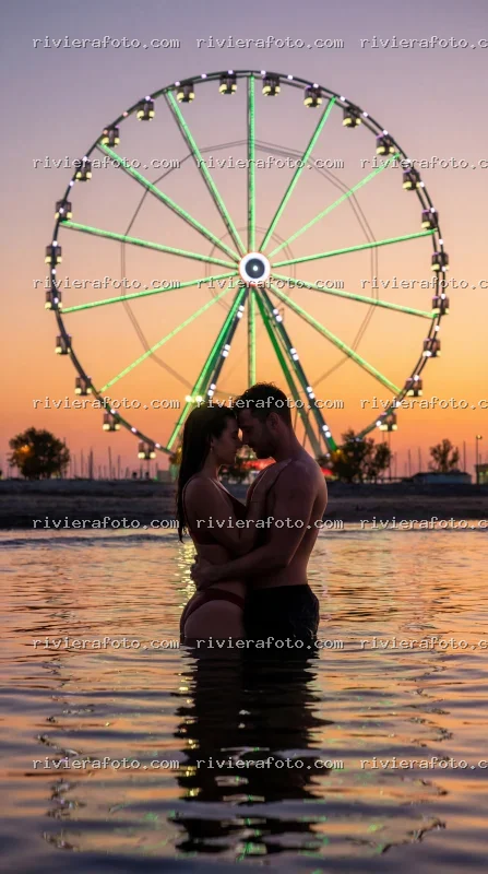 Abbraccio romantico al tramonto sulla spiaggia di Rimini con Ruota Panoramica
