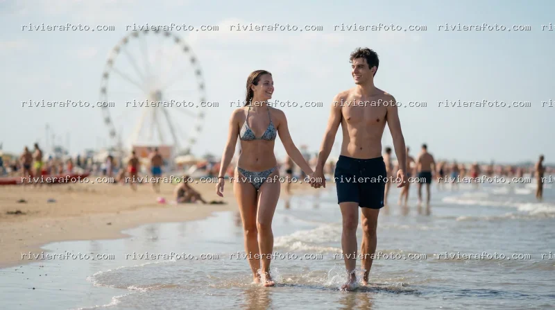 Coppia sulla spiaggia di Rimini sulla Riviera Romagnola con ruota panoramica