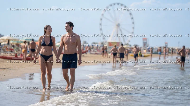 Coppia sulla spiaggia di Rimini con la Ruota Panoramica sullo sfondo