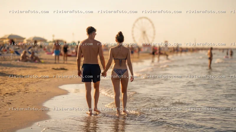Passeggiata al tramonto sulla spiaggia di Rimini nella Riviera Romagnola con ruota panoramica
