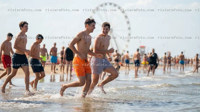 Giovani in spiaggia a Rimini con la Ruota Panoramica