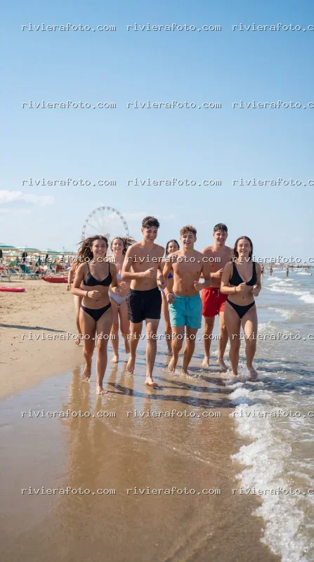 Giovani sulla spiaggia di Rimini con Ruota Panoramica