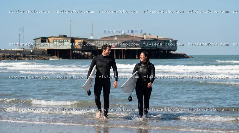 Surfisti sulla spiaggia di Rimini con Rockisland sullo sfondo