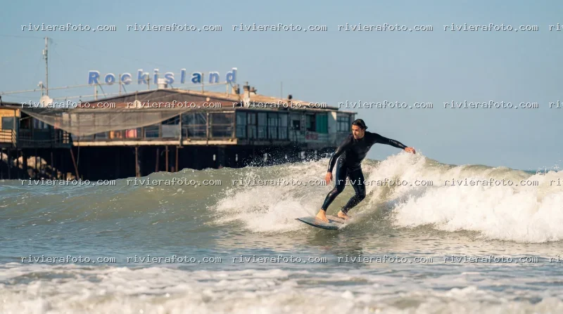 Surfer con Rockisland di Rimini sullo sfondo